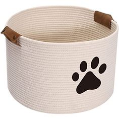 a large white basket with a paw print on the side and brown leather straps around it