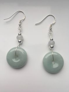 Special sage green jade dangle & drop earrings handmade with quality Chinese jade and 925 Sterling silver hooks and parts. The fine light smoky green jade and white small jade ball are icy and natural. Minimalist and delicate design inspired by traditional Chinese decorations. Some highlights of this pair of cute Chinese jade earrings are: ＊High-quality materials Hand made with grade-A natural green & white jade and 925 sterling silver. ＊Simple and graceful Unique sage green jade donut a Nickel-free Round Jade Jewelry, Dangle Jade Earrings With Matching Set, Jade Dangle Earrings Jewelry Set, Jade Dangle Earrings For Pierced Ears, Round Jade Jewelry With Matching Earrings, Jade Dangle Earrings With Matching Set, Luxury Dangle Jade Earrings With Matching Set, Nickel-free Round Jade Earrings, Pierced Jade Dangle Earrings