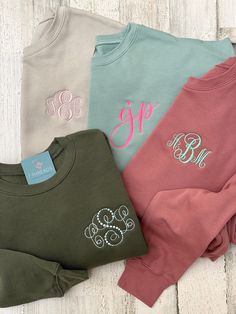 three personalized sweatshirts with monogramming on the front and two different colors