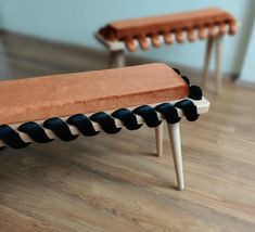 two wooden benches sitting on top of a hard wood floor covered in black and white fabric