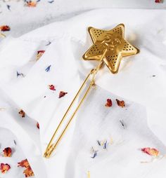 a gold brooch with a star on it sitting on top of a white cloth