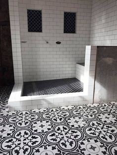 a bathroom with black and white tiles on the floor