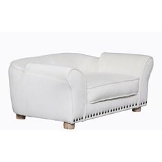 a white leather chair with wooden legs and nail polishing on the armrests