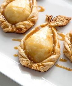 three small pies on a white plate with caramel drizzle