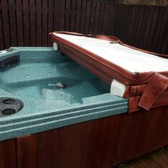 an outdoor hot tub in the middle of a wooden deck