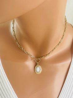 "This is a stunning 14k gold-filled choker chain necklace with a unique two-tone miraculous medal that hangs from toggle clasp in front.  This gorgeous pendant measures 24x15mm, is 925 Sterling silver with gold plating to give it a two-tone look. Made here is the USA by skilled silversmiths this pendant is absolutely incredible. This lovey paper clip chain is made of 14 karat gold filled or can be ordered and 925  sterling silver.  Links measure 8x4mm and 4mm, 3-1 pattern.  Model is wearing a 15\" choker length.  Please measure around your neck to where you want the toggle to land. Comes in a gift box, ready to present! Necklace maybe ordered with a 925 sterling silver chain. Not shown." Gold Miraculous Medal Jewelry, Gold Plated Choker Charm Necklace With Adjustable Chain, Elegant Gold-plated Chain Necklace With Dangling Charms, Dainty Necklace With Miraculous Medal, Elegant Miraculous Medal Necklace, Elegant Gold-tone Sterling Silver Charm Necklaces, Sterling Silver Charm Necklace In Gold, 16 Inch, Gold-toned Sterling Silver Cross Pendant Charm Necklace, Choker Chain