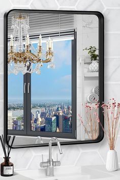 a bathroom mirror with a chandelier hanging from it's side next to a sink