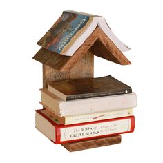 a stack of books sitting on top of each other next to a house shaped book holder