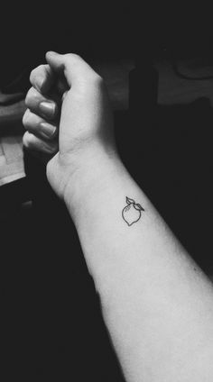 black and white photo of apple tattoo on the left arm, with an apple in the middle