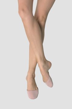 woman's legs in pink ballet shoes on white background