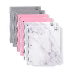 five notebooks lined up next to each other with pink and grey covers on them