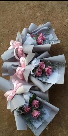 three bouquets of flowers are wrapped in white paper