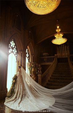 a woman in a wedding dress standing next to a staircase