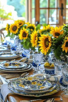 the table is set with sunflowers in vases and dishes on it's sides