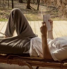 a person laying on a deck reading a book