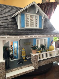 a doll house with a surfboard on the porch