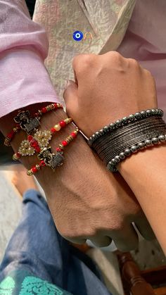 two people holding hands with bracelets on their wrists