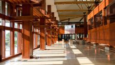 the inside of a building with many windows and wooden beams on each side of it