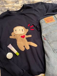 a t - shirt with a monkey on it is laying next to some other items