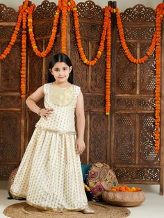 VASTRAMAY Girls' Cream And Gold Jacquard Lehenga Dress your little one in style with this beautiful cream and gold jacquard lehenga set. Features a handcrafted choli with yoke detailing and a lehenga with an elasticated waistband for a comfortable fit. Perfect for festive occasions and special events. Key Features Handcrafted choli and lehenga set Cream and gold jacquard fabric Sleeveless choli with yoke detailing and round neck Tie-up back detailing for adjustability Lehenga with elasticated wa Jacquard Lehenga, Kids Lehenga Choli, Lehenga Dress, Kids Lehenga, Pleated Long Skirt, Indian Festivals, Indian Ethnic Wear, Fabric Silk, Festival Dress