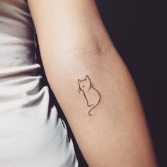 a small cat tattoo on the left arm and right arm, with a black outline