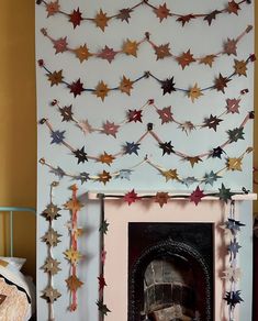 a fire place sitting next to a fireplace covered in paper stars