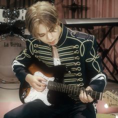 a man in uniform playing an electric guitar