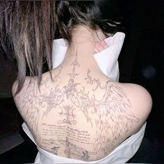 the back of a woman's neck with tattoos on it