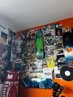 a skateboard is propped up against a wall covered with posters and photos, along with a tripod