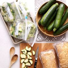 cucumbers, bread and other food items are on the table next to each other