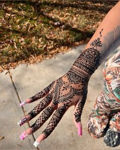 a woman's hand with henna tattoos on it