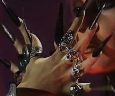 the woman is holding her hands with many rings on them