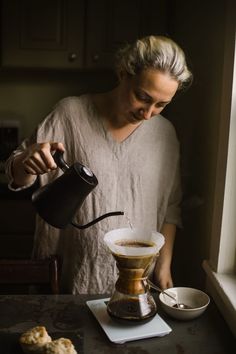 a woman pours coffee into a cup