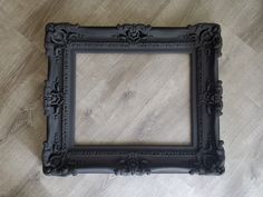 a black frame sitting on top of a wooden floor