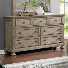 a dresser with a mirror and vases on top of it in a living room