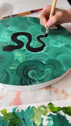 someone is painting the letters s on a green marbled surface