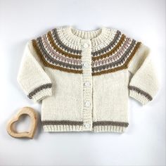 a knitted sweater and wooden heart on a white background