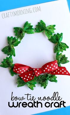 a christmas wreath made out of green leaves and red ribbon on top of a white card