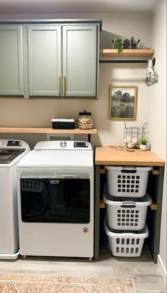 a washer and dryer in a small room next to some cupboards on the wall