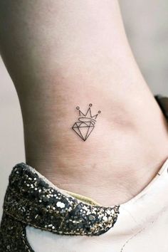 a woman's ankle with a small crown tattoo on the side of her foot