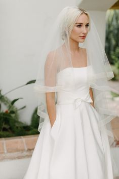 a woman in a white wedding dress and veil