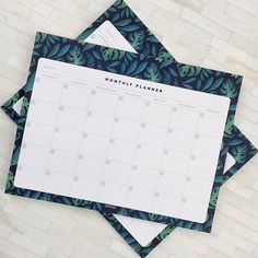 two calendars sitting on top of each other with green leaves around them and the words month planner written in black ink