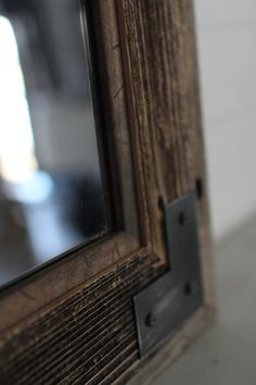 an old wooden frame with a mirror on it