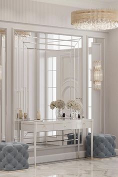 a white dressing table with two chairs and a large mirror on the wall above it