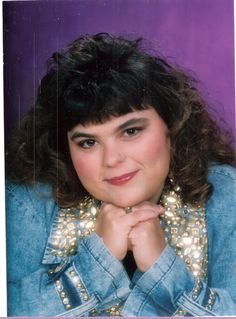 an old photo of a woman with her hands on her chin and wearing a denim jacket