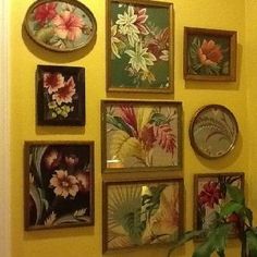 there are many framed pictures on the wall with flowers in them, and one has a potted plant next to it