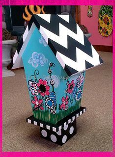 a house made out of cardboard sitting on top of a carpeted floor next to a pink frame