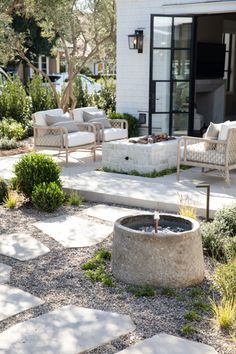 an outdoor living area with chairs and a fire pit