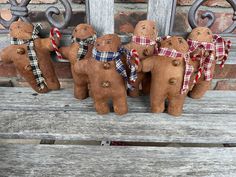 three gingerbread men on a bench with plaid scarves around their necks and ties