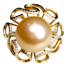 It is a flower motif Pearl ring with ribbon-like petals surrounding the Golden South Sea Pearl. At the edge of the petals there are several round diamonds adding sparkle to the ring. The Golden South Sea Pearl is measuring 13mm-14mm The pearl is of Excellent Lustre and very minor Surface Blemish The Pearl is in Rich Golden Colour with Pink Overtone Total Natural Diamond weight is 0.131 ct US Ring Size is 7 1/2 , The Inner Diameter of the Ring is 17.73 mm Golden Colour, Golden South Sea Pearls, Pearl And Diamond Ring, Sea Pearl, Flower Motif, South Sea Pearls, Sea Pearls, Women Diamond, Pearl Diamond